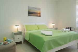 um quarto com uma cama verde, 2 mesas de cabeceira e 2 candeeiros. em La Coccinella Sorrento em Sorrento