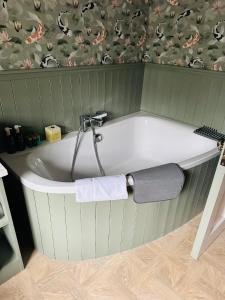 a bath tub with a towel on the side of it at Glenastar Lodge in Newcastle West