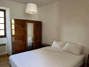 Saint Alban AuriollesにあるMaison de Campagne au bord de l'eauのベッドルーム(白いベッド1台、鏡付)
