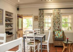 comedor con mesa y sillas en Via's Guesthouse en Greyton