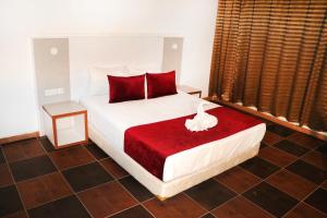 1 dormitorio con cama blanca y almohadas rojas en Hotel Hayatt Atlantique, en Nouakchott