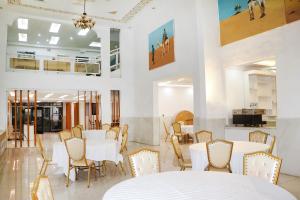 un comedor con mesas y sillas blancas en Hotel Hayatt Atlantique, en Nouakchott