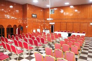 una sala de conferencias con sillas rojas y una mesa blanca en Hotel Hayatt Atlantique, en Nouakchott