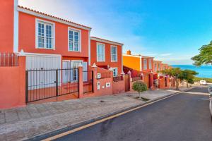 eine Reihe orangefarbener und gelber Häuser auf einer Straße in der Unterkunft Nice House Nina With Jacuzzi in Playa de San Juan