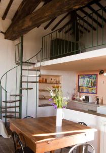 a dining room with a table and a spiral staircase at Torrione Apartment in Panzano