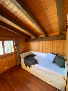 łóżko w domku z drewnianymi ścianami w obiekcie Casa Plaun Martin w mieście Ruschein