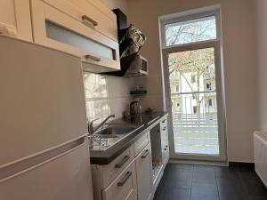 ライプツィヒにある3 room apartment center eastのシンクと大きな窓のあるキッチン
