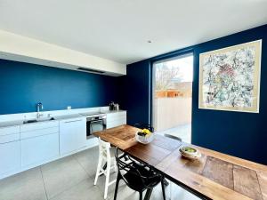 普瓦捷的住宿－Beautiful family home，厨房配有木桌和蓝色的墙壁