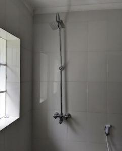 La salle de bains est pourvue d'une douche et d'un miroir. dans l'établissement WHITE HOUSE GARDEN, à Moshi
