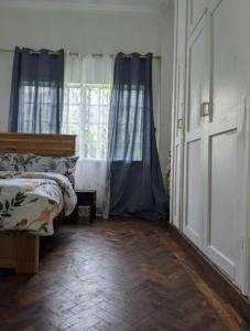 een slaapkamer met een bed en een groot raam bij WHITE HOUSE GARDEN in Moshi