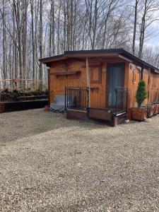 a large wooden cabin with a porch in the woods at Camping Febbio 2000 in Villa Minozzo