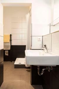 a bathroom with a white sink and a mirror at Spacious Family Apartment at Mauerpark plus SelfCheckIn in Berlin +14 photos