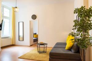 a living room with a couch and a clock on the wall at Spacious Family Apartment at Mauerpark plus SelfCheckIn in Berlin