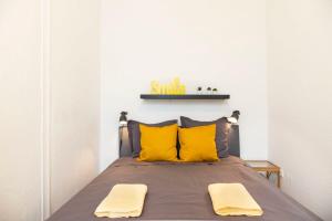 a bedroom with a bed with two yellow pillows at Spacious Family Apartment at Mauerpark plus SelfCheckIn in Berlin