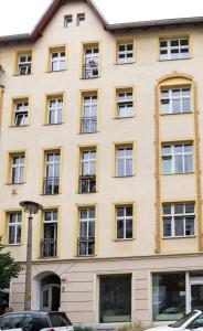a large yellow building with windows at Spacious Family Apartment at Mauerpark plus SelfCheckIn in Berlin