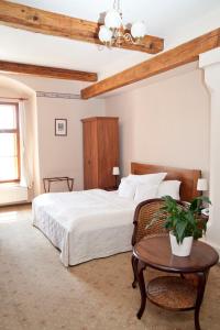 a bedroom with a white bed and a table at Hotel U Zlatého Lva in Havlíčkŭv Brod