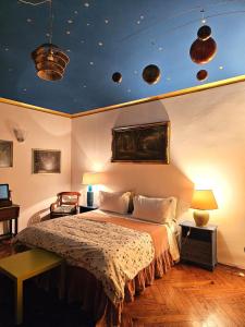 una camera da letto con un grande letto e un soffitto blu di Aedel Lxr a Torino