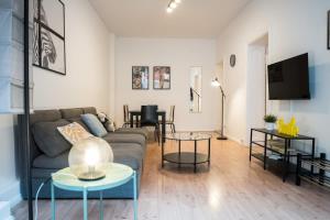 Great Apartment for Eight in Berlin Neukölln في برلين: غرفة معيشة مع أريكة وطاولتين