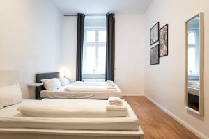 Great Apartment for Eight in Berlin Neukölln في برلين: سريرين في غرفة بها نافذتين