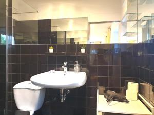 a bathroom with a white sink and a mirror at Cosy Studio with Private Parking in Hamburg