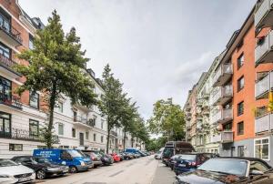 una fila de autos estacionados en una calle con edificios en Two Bedroom Apartment and Bathrooms, en Hamburgo