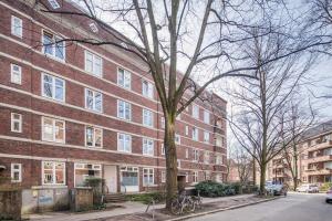 un grand bâtiment en briques rouges dans une rue de la ville dans l'établissement Schickes zwei Zimmer Apartment Kostenl Parkm auf der Strasse, à Hambourg