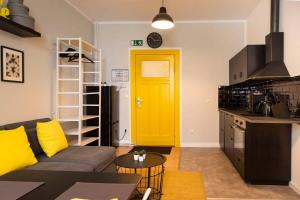 a living room with a couch and a yellow door at Lovely Apartment in the near of Kudamm in Berlin