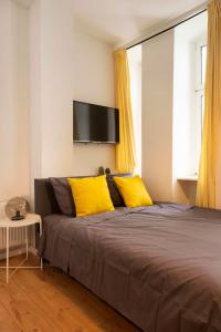 a bedroom with a large bed with yellow pillows at Lovely Apartment in the near of Kudamm in Berlin