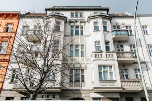 柏林的住宿－Stylish Apartment in convinient location，前面有棵树的白色建筑