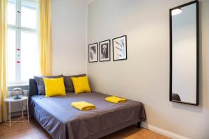 a bedroom with a bed with yellow pillows and a mirror at Kudamm plus AC plus SelfCheckIn plus Free Street Parking in Berlin