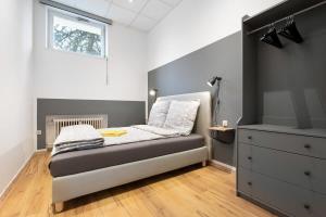 ein Schlafzimmer mit einem Bett, einer Kommode und einem Fenster in der Unterkunft Big Central Apartment near Rotkreuzplatz with 3 BR for 12 PAX in München