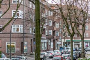 Une rangée de voitures garées dans un parking en face des bâtiments dans l'établissement Studio Family Loft Self CheckIn Street Parking, à Hambourg