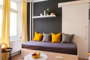 a bedroom with a bed with yellow pillows and a table at 2 Bedroom in great location in Kreuzberg in Berlin