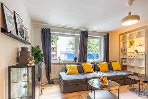 ein Wohnzimmer mit einem grauen Sofa und gelben Kissen in der Unterkunft 3 Bedroom apartment in great location in Hamburg