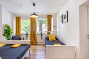 two beds in a small room with yellow curtains at 3 Bedroom apartment in great location in Hamburg