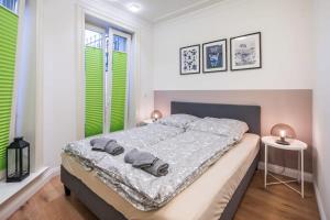 a bedroom with a large bed with green shuttered windows at Charming Apartment in prime location in Hamburg