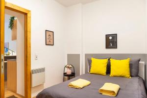 een slaapkamer met een bed met gele kussens bij Cozy 2 room apartment next to Hermannstraße in Berlijn