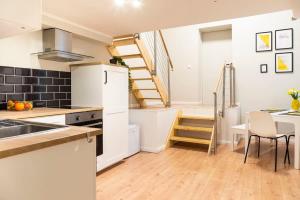 a kitchen with a staircase leading up to a loft at SPACIOUS Two BR plus AC plus SelfCheckIn in Berlin