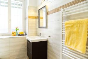 ein Bad mit einem Waschbecken und einem gelben Handtuch in der Unterkunft Industrial Style plus Self Checkin plus Street Parking in Berlin