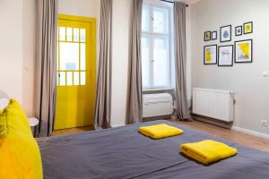 a bedroom with a bed with two yellow pillows on it at SPACIOUS Two BR plus AC plus SelfCheckIn in Berlin
