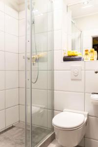 La salle de bains est pourvue de toilettes et d'une douche en verre. dans l'établissement SPACIOUS Two BR plus AC plus SelfCheckIn, à Berlin