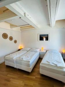 deux lits dans une chambre aux murs blancs dans l'établissement Hamburger Perle am Gänsemarkt und Binnenalster, à Hambourg