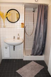 uma casa de banho com um lavatório e um chuveiro em Hamburger Perle am Gänsemarkt und Binnenalster em Hamburgo