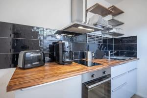 una cucina con piano di lavoro in legno e forno a microonde di 1 Schulterblatt-Apartments Hamburg For 6 ad Amburgo