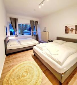 1 dormitorio con 2 camas y ventana grande en Apartment 1 Hamburg Winterhude, en Hamburgo