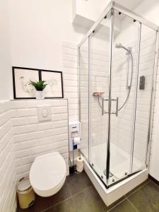 a bathroom with a toilet and a glass shower at Apartment 1 Hamburg Winterhude in Hamburg