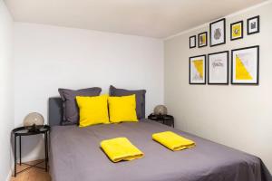 a bedroom with a large bed with yellow pillows at Loft Apart plus AC plus SelfCheckIn in Berlin