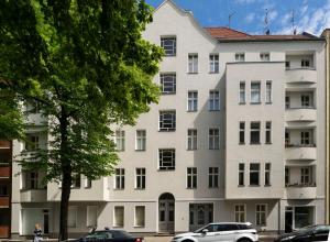 een wit gebouw met auto's ervoor geparkeerd bij Great Apartment close to Kudamm in Berlijn
