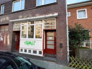 a brick building with a red door on a street at Spacious Apt for 9 in great location in Hamburg