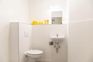 une salle de bain blanche avec toilettes et lavabo dans l'établissement Cosy loft style Apartment in Berlin Wilmersdorf, à Berlin 13 autres photos